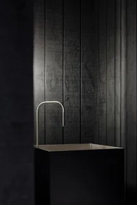 A modern metal sink with a minimalist, industrial design.