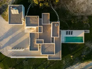 Aerial view of a minimalist house with a concrete exterior.