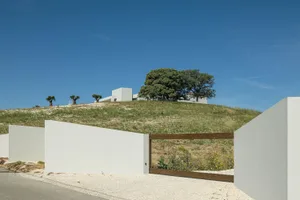 Modern minimalist house with concrete walls and a hillside location.