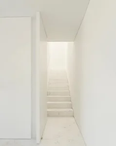 A minimalist staircase made of white marble in a modern interior design setting.