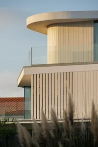 Modern residential exterior featuring a glass and concrete design.