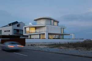 Modern residential exterior featuring white panels and glass.