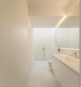 Modern, minimalist bathroom with marble flooring and walls.