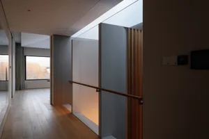 Modern minimalist corridor with glass panels and wooden flooring