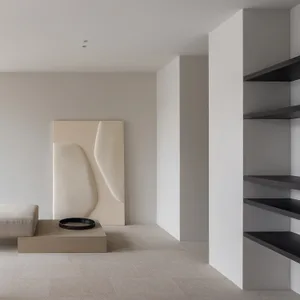 A minimalist living room with concrete walls and furniture.