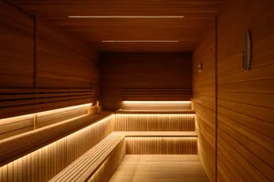 A modern, warm wooden sauna with ambient lighting and built-in benches.