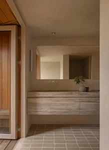 A modern bathroom featuring a concrete waterfall sink and minimalist design