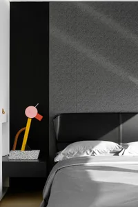 Modern minimalist bedroom featuring a black upholstered headboard and gray bedding.