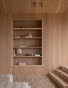A minimalist room with wooden bookshelves and a tiled floor.