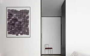 A minimalist interior design featuring a modern art print with a purple geometric grid pattern.
