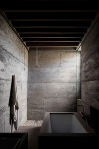 Concrete bathroom with industrial design elements, including exposed beams and minimalist fixtures.