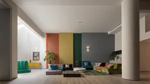 Contemporary living room featuring a vibrant color-block accent wall, plush seating, and natural light.