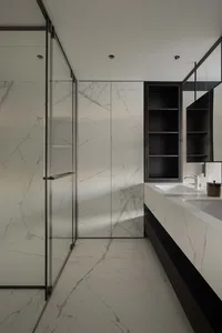 Modern bathroom with marble walls and floor, featuring a glass shower enclosure and a floating vanity.