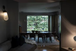 Modern dining room featuring leather chairs and a glass dining table surrounded by a cozy seating area.