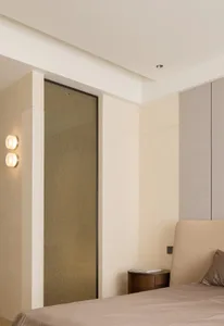 A modern minimalist bedroom with cream-colored walls and a bed.