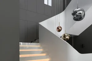 Modern, white marble staircase with metallic accents and illuminated steps.
