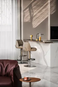 Image of a modern minimalist kitchen featuring marble countertops and bar stools.