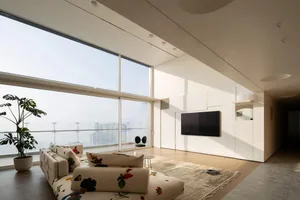 Modern industrial living room featuring large glass windows.