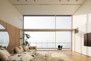 Modern minimalist living room with wooden features including a comfortable couch adorned with colorful throw pillows and side