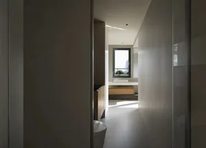 A minimalistic bathroom with white walls and floor, featuring a modern sink and tub.