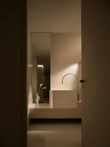 Minimalist modern bathroom with concrete sink, mirror, and lighting