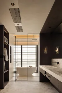 Modern bathroom with marble countertops and flooring, featuring a freestanding bathtub.