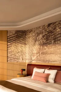 A modern bedroom with wooden texture walls, a large bed, and soft, plush bedding.