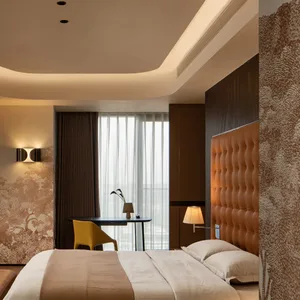 Modern bedroom featuring a luxurious leather upholstered bed and elegant decorative elements.