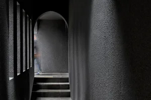 A modern staircase constructed from concrete, with a minimalist design and a single step visible.