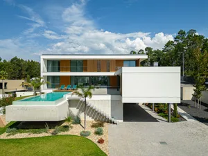 A modern house with a concrete exterior and glass features.