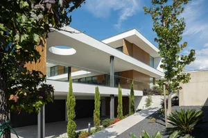 Modern residential building featuring concrete, glass, and wood materials.