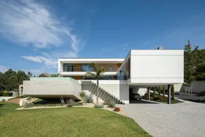 A modern residential home featuring concrete and glass materials with a floating design