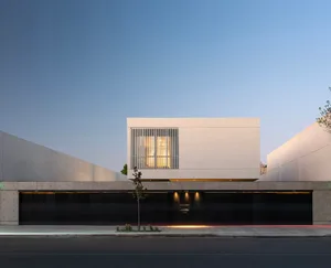Modern concrete building with large windows and minimalistic design.