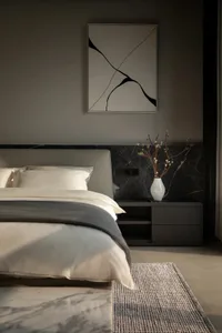 Minimalist bedroom with a bed, nightstand, and abstract art.