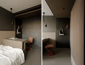 A minimalist bedroom with a study area featuring wooden furniture and a blackboard wall.