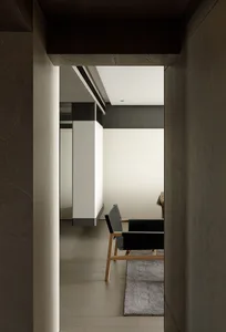 Modern minimalist living space with sleek black furniture and white walls.