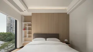 A minimalist bedroom featuring wood-paneled walls, a white bed with light-colored bedding, and a modern, open shelving unit.