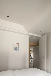 Modern minimalist bedroom with white matte furniture and a wall art