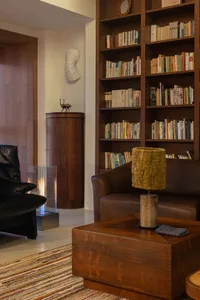 Modern industrial living room with wood, leather, and glass elements.