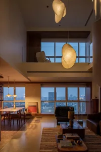 A modern lounge area featuring wood furniture and a large window with cityscape views.