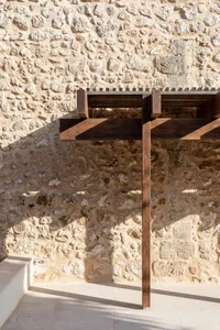 A stone wall with a wooden beam structure attached to it.