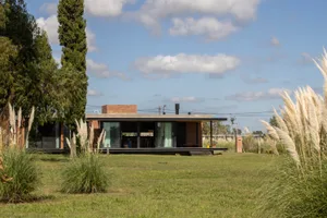 A minimalist residential building exterior featuring brick, concrete, and glass materials.