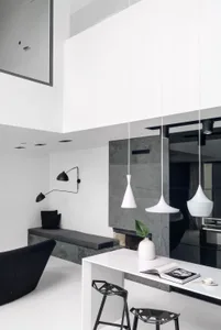 Modern minimalist kitchen with concrete materials and white pendant lights.
