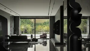 Modern interior design of a living room featuring sleek black furniture and glass floors.