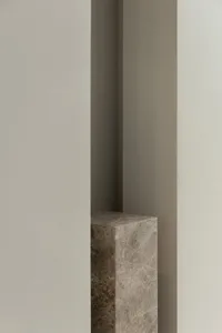 Close-up image of a modern interior concrete column against a plain wall background.