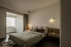 Minimalist bedroom featuring a bed with simple, clean lines, and a minimalistic color palette.
