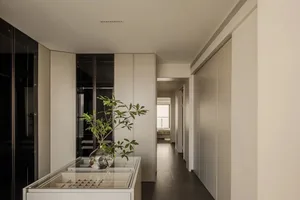 Modern residential interior featuring white walls, wooden flooring, and glass elements.