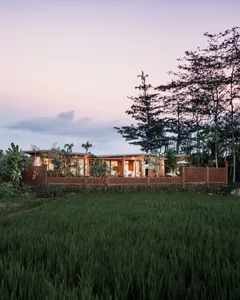 A modern house with a concrete exterior and wooden accents featuring a lush garden and swimming pool.