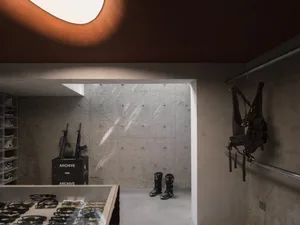 A minimalist retail space featuring concrete walls, metal accents, and modern design elements.