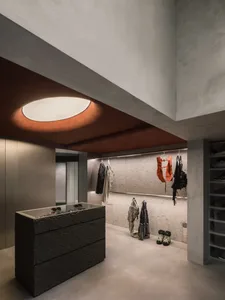 Modern industrial clothing retail store interior with concrete walls and minimalist design.
